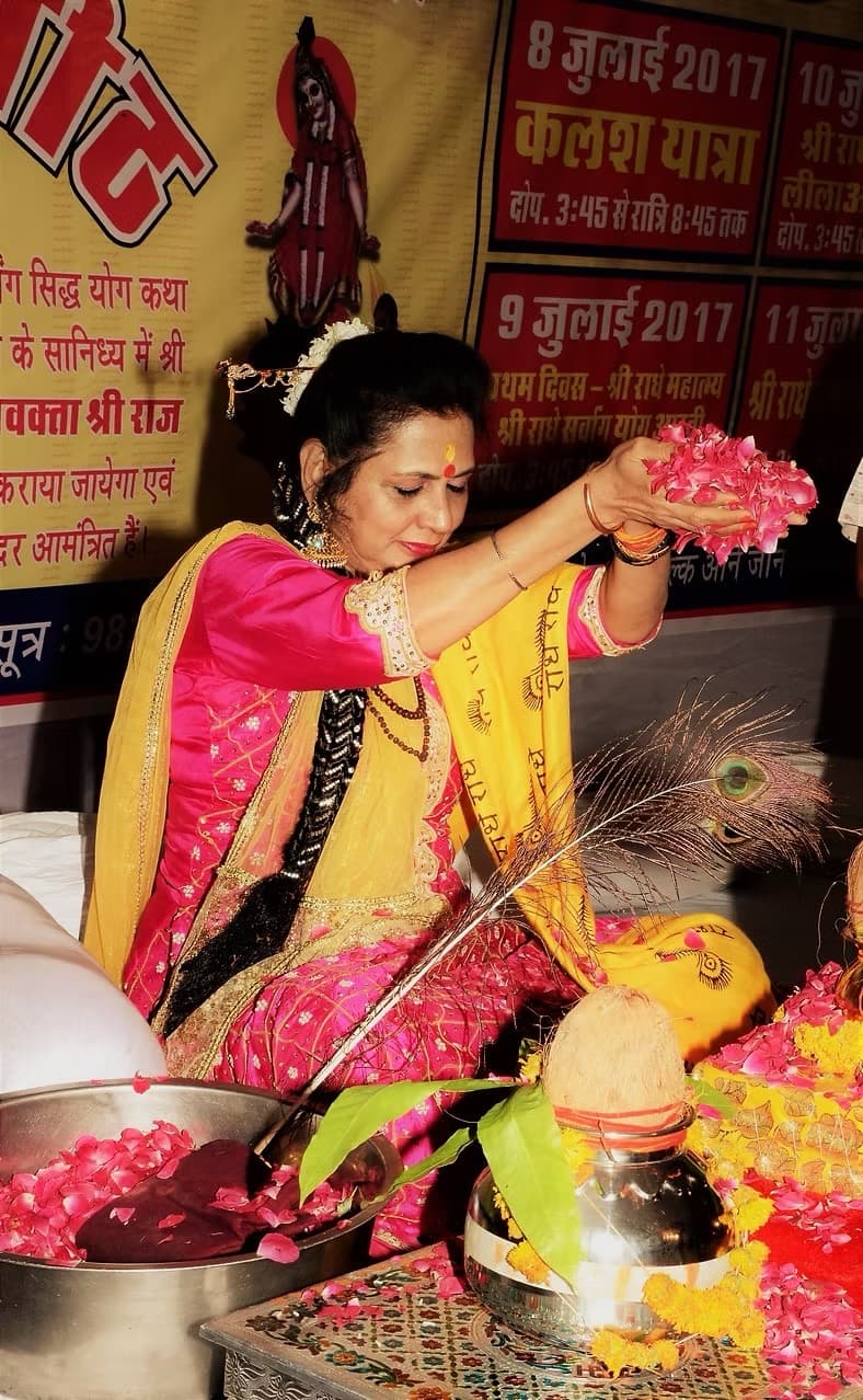 Shri Maa Dr. Sushma Pandey (Ananya Ji) offering rose petals during a sacred puja.